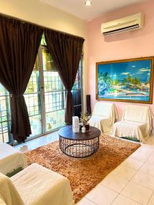 a living room with a coffee table and large windows at RUMAH SANTAI in Sungai Petani