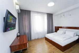 a bedroom with a large white bed and a television at Hotel type rooms on avenue Melikishvili, city center in Tbilisi City