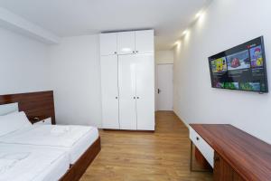 a bedroom with a bed and a tv on the wall at Hotel type rooms on avenue Melikishvili, city center in Tbilisi City