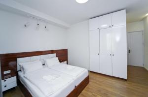 a white bedroom with a large bed and white cabinets at Hotel type rooms on avenue Melikishvili, city center in Tbilisi City