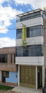 un edificio con un cartello giallo sopra di Hospedaje EL RINCONCITO II a Jauja