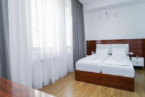 a bedroom with a bed with white sheets and a window at Hotel type rooms on avenue Melikishvili, city center in Tbilisi City