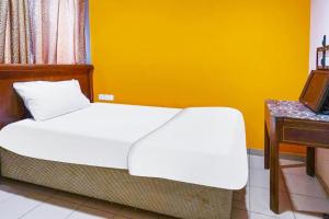 a bedroom with a white bed and a desk at K T M HOTEL KLANG in Klang