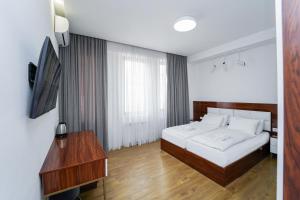 a bedroom with a bed and a table and a television at Hotel type rooms on avenue Melikishvili, city center in Tbilisi City