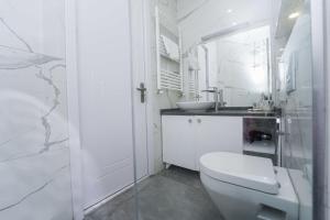 a white bathroom with a toilet and a sink at Hotel type rooms on avenue Melikishvili, city center in Tbilisi City
