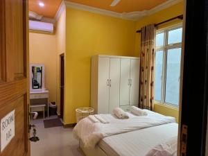 1 dormitorio con 1 cama con toallas en Maavaharu - K.Huraa, en Huraa