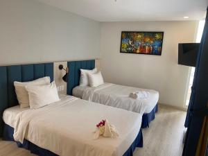 a hotel room with two beds and a painting on the wall at Maldives B3-30 Oceanami Villas & Beach Club in Long Hai