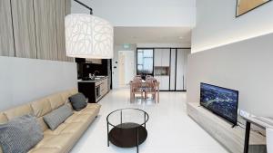 a living room with a couch and a tv at Moulmein Studios by K&C Serviced Apartment in Singapore