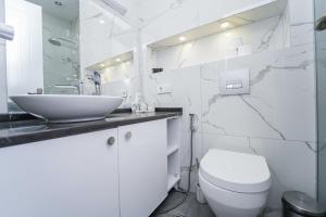 a white bathroom with a sink and a toilet at Hotel type rooms on avenue Melikishvili, city center in Tbilisi City
