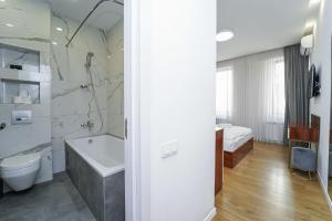 a bathroom with a tub and a toilet and a sink at Hotel type rooms on avenue Melikishvili, city center in Tbilisi City