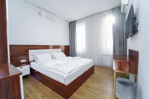 a bedroom with a large white bed and a television at Hotel type rooms on avenue Melikishvili, city center in Tbilisi City