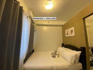 a small room with a bed and a window at Shore Residence D22 shortwalk MOA Balconypoolview in Manila