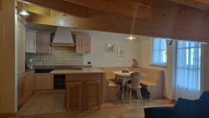 a kitchen with wooden cabinets and a table in it at Appartamenti Residence Rodolon Fontanazzo in Campestrin