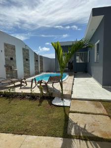 una casa con una piscina y una palmera en Jacuipe Sun House, en Camaçari