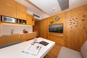 a kitchen with wooden cabinets and a white table at Shama Hub Metro South Hong Kong in Hong Kong