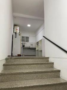 an empty room with stairs and a refrigerator at Departamento Centro in Concepción del Uruguay