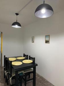 Habitación con mesa con sillas y 2 luces en Departamento Centro en Concepción del Uruguay