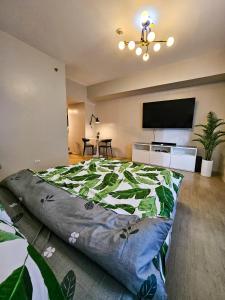 une chambre avec un grand lit et une télévision à écran plat dans l'établissement Brand New Central Convenience Studio Condo with Balcony in Araneta City Cubao, à Manille
