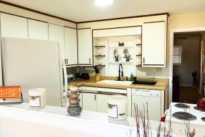 a kitchen with white cabinets and a white refrigerator at Kids,Pets, friendly 3BR 2BT Game Bonus, Room Fenced in Fayetteville