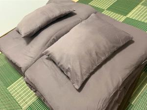 a bed with two pillows on top of it at SAKURA Stay FUKUOKA2 in Fukuoka