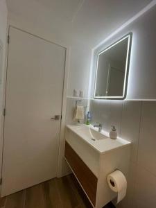 a white bathroom with a sink and a mirror at Getaway near Airport in Guatemala