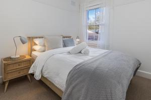 Un pat sau paturi într-o cameră la Luxe-Coastal Balmoral Beachfront Apartment