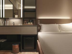 um quarto com uma cama, um lavatório e um espelho. em Hotel 1900 Express Chinatown em Singapura