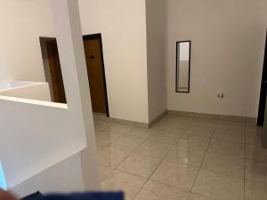 a white room with two doors and a tiled floor at Habitaciones ENMA in Ciudad Juárez