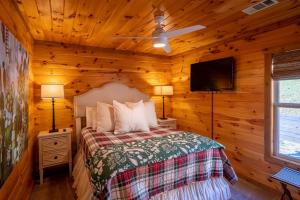 1 dormitorio con 1 cama y TV de pantalla plana en Cottages @ Julep Farms, en Dillard
