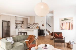 ein Wohnzimmer mit einem Sofa und einer Küche in der Unterkunft Architect Home with View in Central Hobart in Hobart