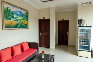 a living room with a red couch and a refrigerator at Rama House in Ubud