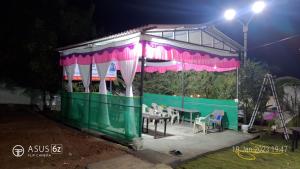 cenador con mesa y sillas por la noche en DR BHOIR FARM & RESORT, en Kalyan