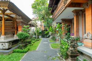 a courtyard of a building with trees and plants at Rama House in Ubud