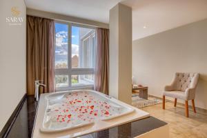 a bath tub in a room with a large window at Saray Pyramids & Museum View Hotel in Cairo