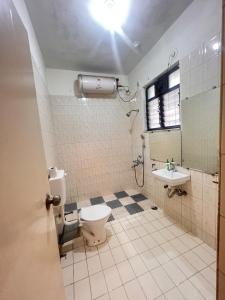 a bathroom with a toilet and a sink at Rostel Backpackers Hostel in Pune