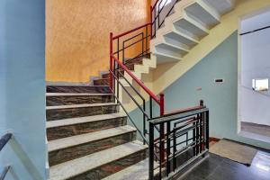a staircase in a house with a red railing at OYO Flagship Jashwanth Residency in Mysore