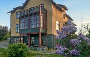 uma casa grande com flores em frente em Amazing Home In Lindesberg With House Sea View em Lindesberg