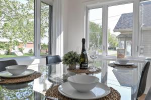 a dining room with a table with a bottle of wine at Villa luxueuse avec vue sur le fleuve Villa GrandeCasa in Trois-Rivières