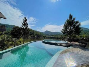 a swimming pool with a view of a mountain at Thang Mây Village Resort in Ba Vì