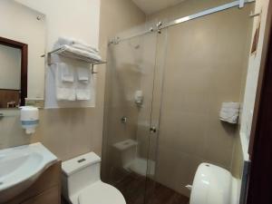 een badkamer met een douche, een toilet en een wastafel bij Casona Tobar Hotel in Rocafuerte