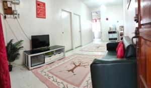 a living room with a couch and a tv at SUFIZA Residence in Kangar