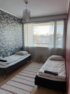 a bedroom with two beds and a window at Kustaan neliö in Kokkola