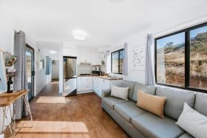a living room with a couch and a kitchen at Canguri Boutique - A Memorable Farmstay near Mudgee in Mudgee