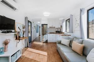 a living room with a couch and a kitchen at Canguri Boutique - A Memorable Farmstay near Mudgee in Mudgee