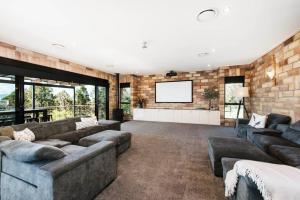 ein großes Wohnzimmer mit Sofas und einem TV in der Unterkunft 'Tyalla Lodge' Unique Luxe Design in the Mountains in Mudgee