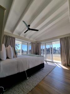 1 dormitorio con 1 cama y ventilador de techo en Pipeclay Cottage - Farmstay Vibes and Chic Design en Eurunderee
