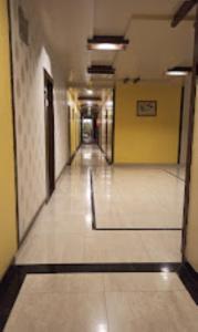 an empty hallway in a building with yellow walls at Hotel Bhagyalaxmi , Shirdi in Shirdi