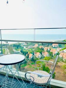 a balcony with a table and chairs and the ocean at Homestay The Sóng căn hộ nghỉ dưỡng tốt nhất năm 2024 in Vung Tau