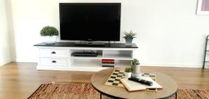 ein Wohnzimmer mit einem TV in einem weißen Unterhaltungszentrum in der Unterkunft Mt Clear Ballarat Holiday Homes - Only minutes to Sovereign Hill and Ballarat CBD - Sleeps 1 to 4 in Ballarat