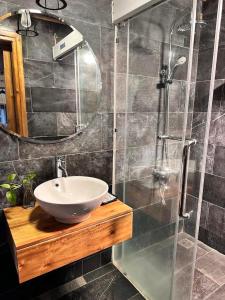 a bathroom with a sink and a glass shower at Thang Mây Village Resort in Ba Vì